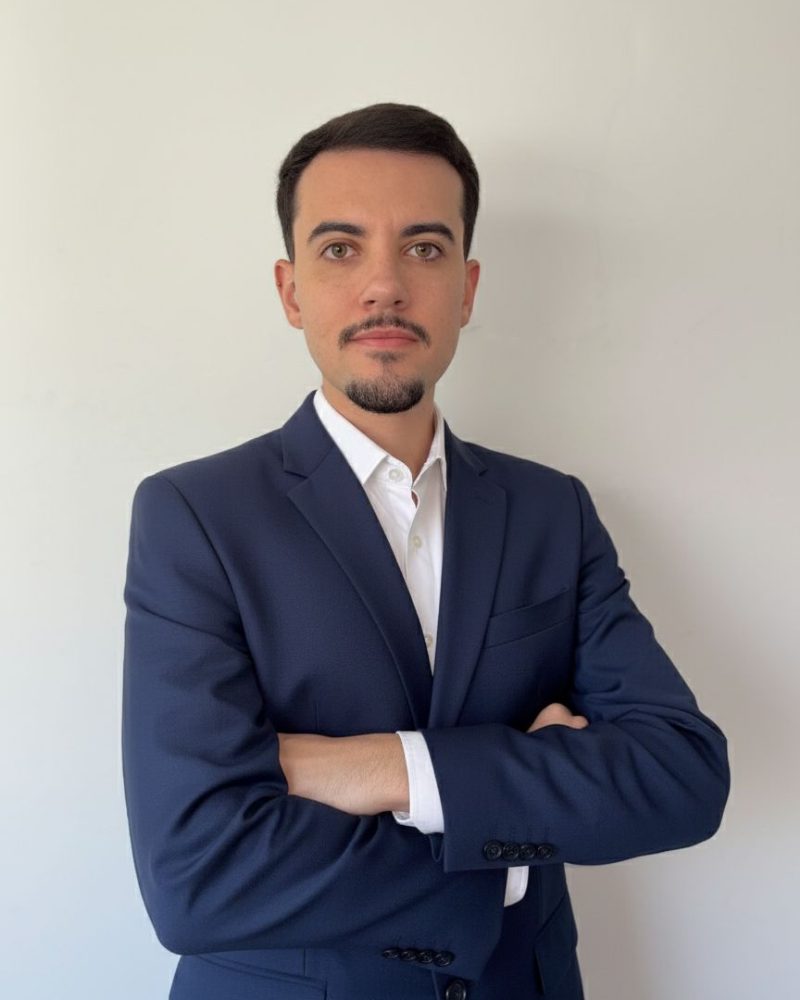 Retrato do advogado Cesar Alves, de braços cruzados, vestindo terno azul-marinho